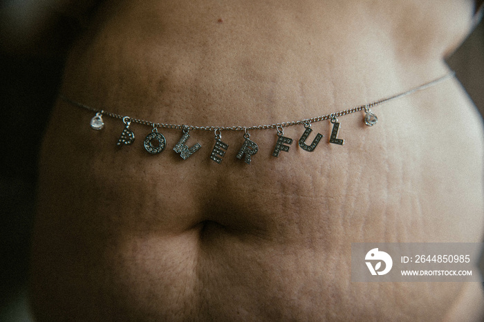 close up portrait of a tummy with stretchmarks with POWERFUL body chain