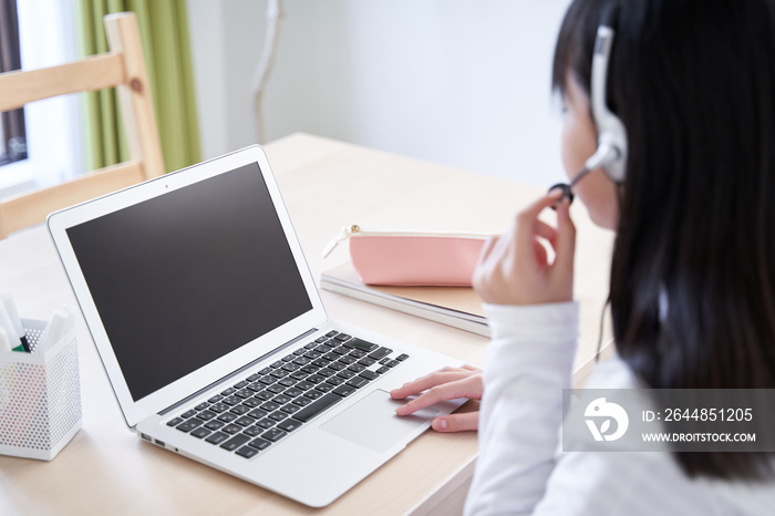 リビングでオンライン講義を受ける日本人女子中学生