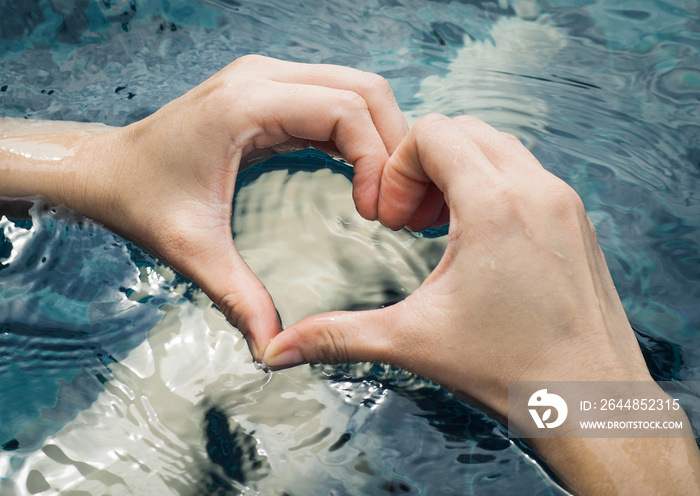 Color filter and selective focus, Heart from hands on swimming pool (Concept ,Love, Health)