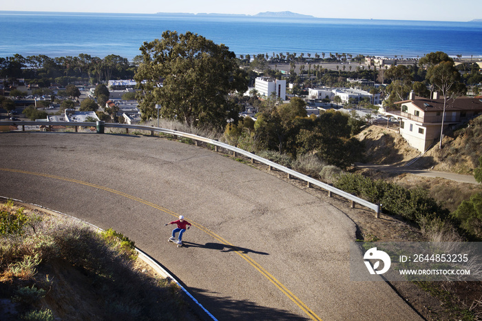 High angle view of man skateboarding on road by town and sea