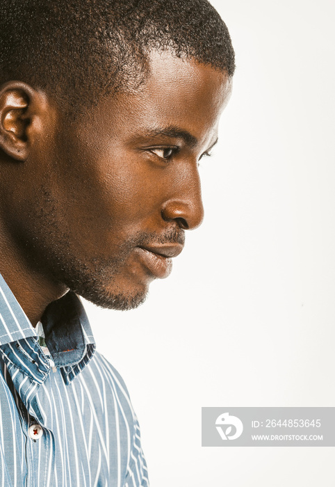 Profile view of African American man in a blue striped shirt. Close-up portrait of an attractive dar