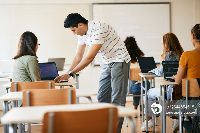 计算机科学教授在高中课堂上帮助他的学生。