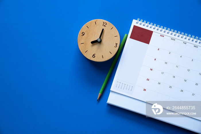 close up of calendar and alarm clock on the blue table background, planning for business meeting or 