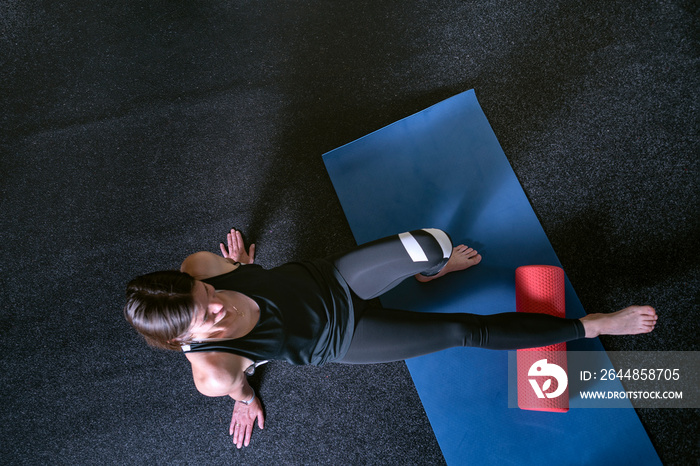 Athlete kneads the muscles of the legs with MFR roller. Top view. Roller to roll out calf muscles.