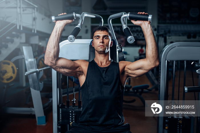 Tanned man training on exercise machine