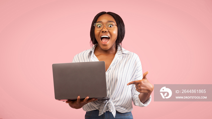 Excited Afro Girl Pointing Finger At Laptop, Pink Background, Panorama