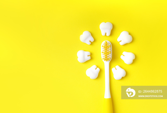 带牙齿的牙刷模型在黄色背景上制造太阳。复制空间。