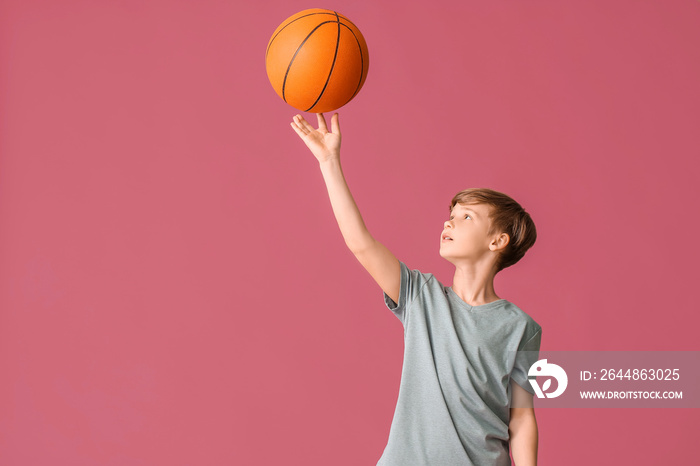 Cute little basketball player on color background