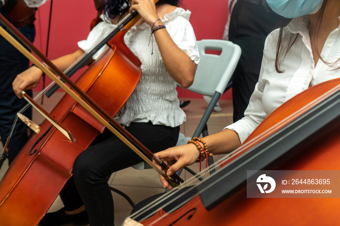 Hispanic girl having music lessons of cello during coronavirus pandemic.