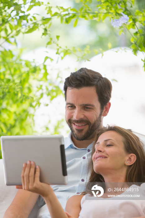 Couple using digital tablet on patio