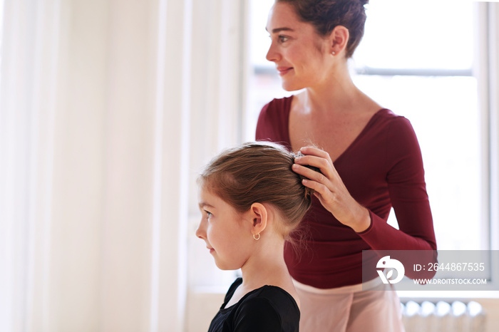 Young woman checking ballet dancers hairstyle