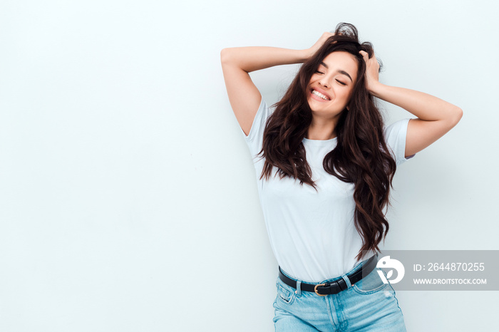 Excited young girl in a white T-shirt holds her head and is genuinely happy. People sincere emotions