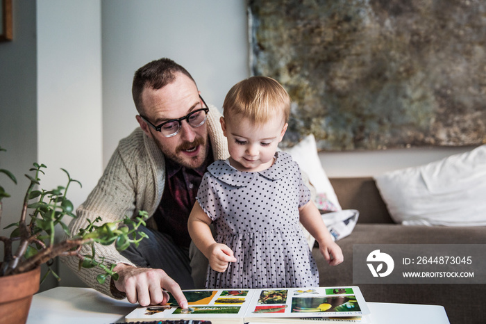 Father and daughter looking at book