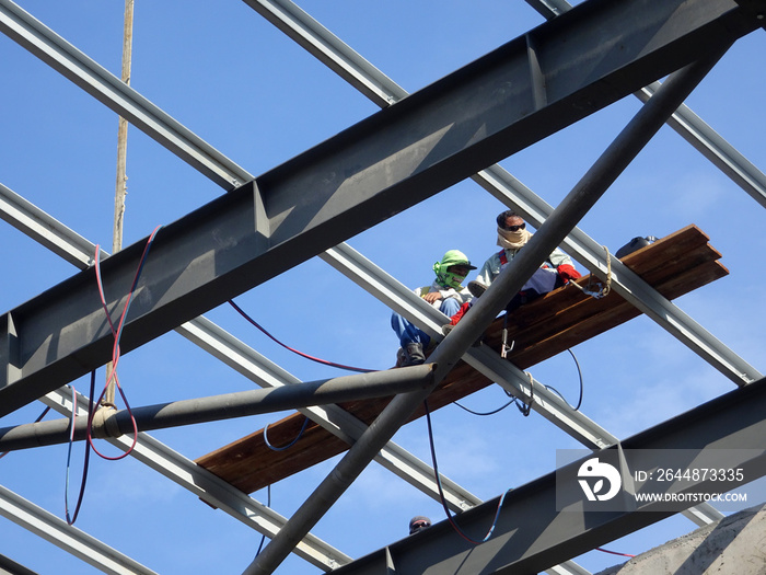 Metal roof trusses installed by construction workers. The metal trusses used to support metal roof s