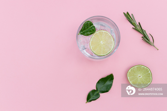 Gin tonic cocktail drink in glass on summer pink background