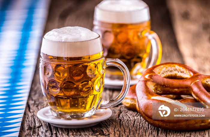 Beer. Oktoberfest.Two cold beers and pretzel. Draft beer. But draft. Golden beer. Golden however. Tw