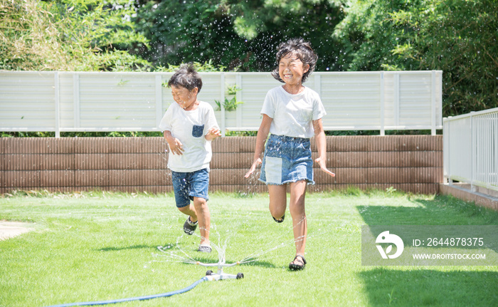 庭で水遊びをする子供