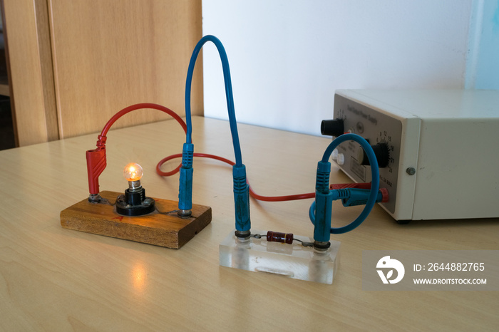 Electrical experiment in physics laboratory. Electrical circuit with resistance and light bulb.