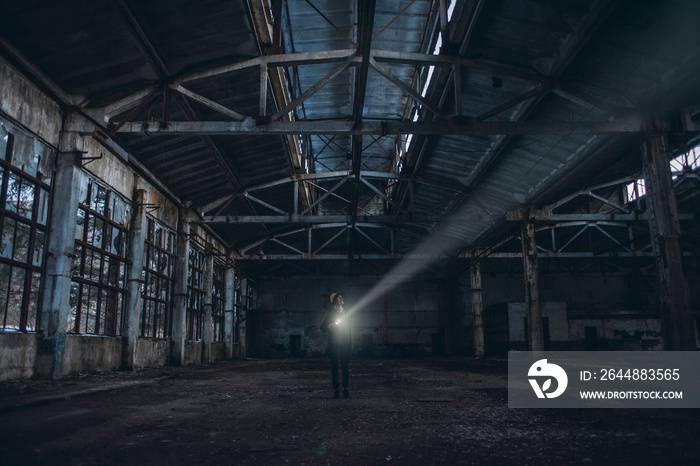 Lonely Boy with a Flashlight Walks in an Abandoned Room