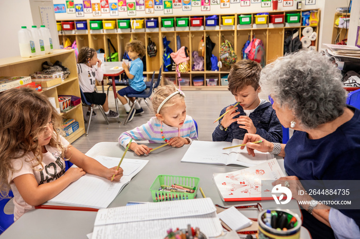 Teacher helping children with their classwork