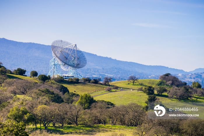 Telecommunications antenna high on green hills on a sunny day