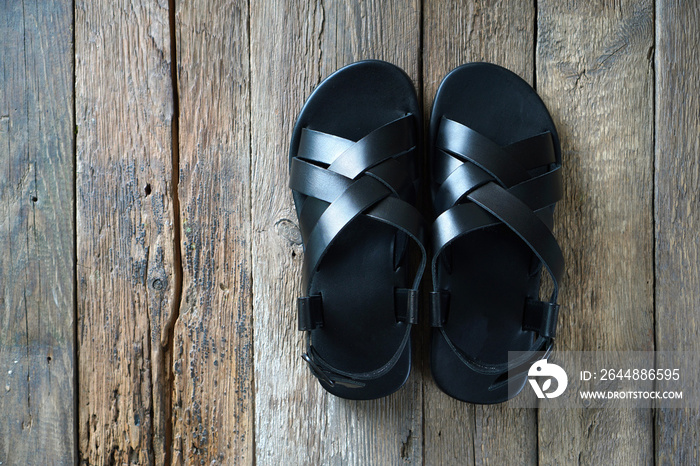 New leather mens sandals on the wooden floor. Top view. Copy space.