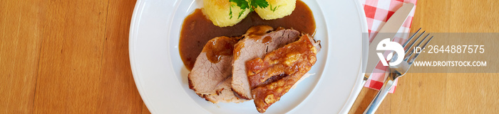 Saftiger krosser Schweinebraten mit Kruste und Knödel mit Sauce