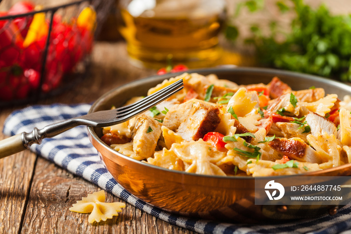 Pasta farfalle with chicken and paprika, in carbonara sauce.