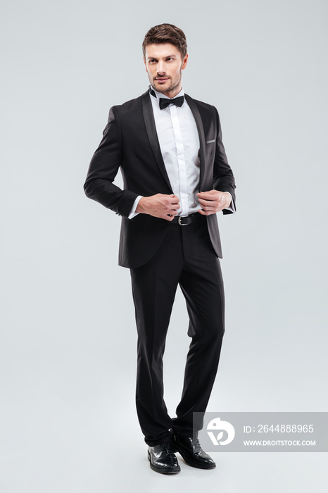Full length of handsome young man in tuxedo with bowtie