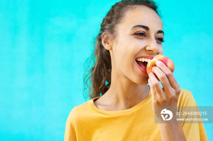 Portrait of healthy young woman eating fresh ripe tasty yellow-red apple with delighte, healthy snac
