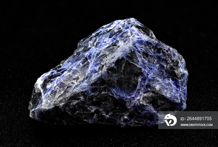 Black and blue sodalite mineral stone specimen on a black background