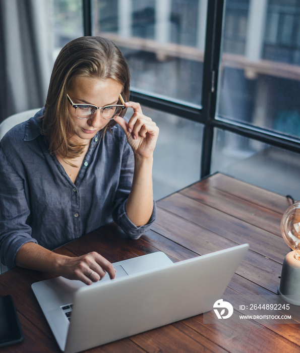 Woman working on laptop. Freelancer at remote work. Female student learning on-line via computer. Bl