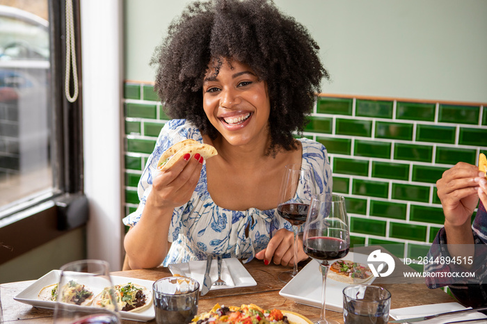 �UK, London, Smiling woman enjoying Mexican food at restaurant table