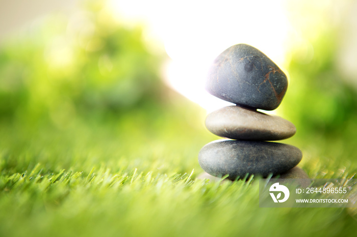 balance  with a pyramid of stone on fresh nature green grass  , spa meditation or well-being with ze