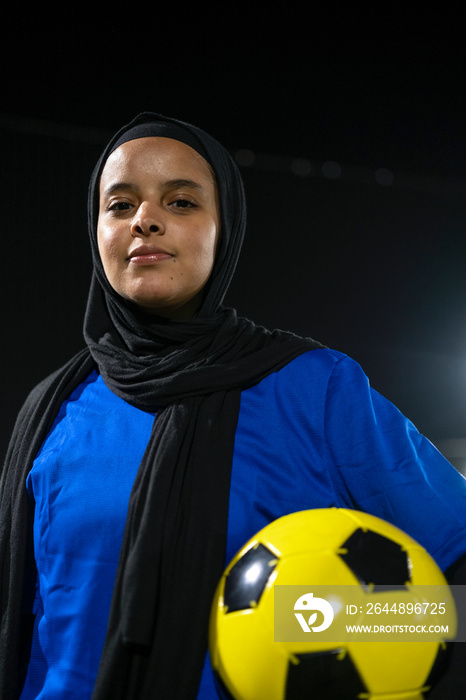 Portrait of female soccer player holding ball