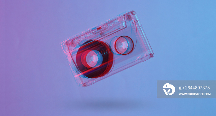 Minimalism retro style concept. 80s. Audio cassette in neon red blue light. Glitch effect