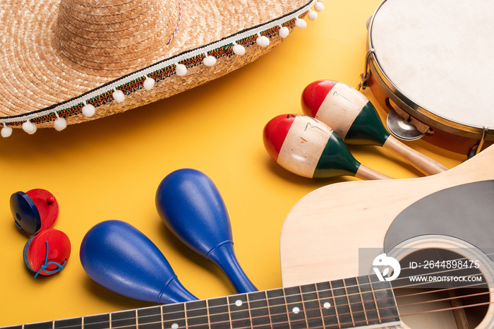 Musical instruments and mexican sombrero on yellow background