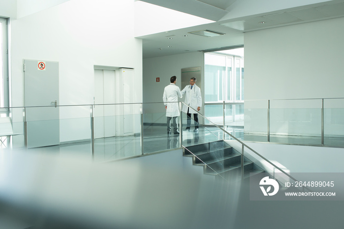 Doctors shaking hands in hospital corridor