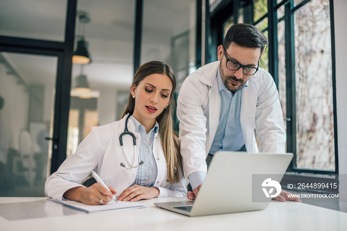 Portrait of a two doctors working in medical office.