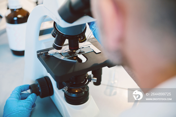 Científico trabajando en laboratorio con microscopio