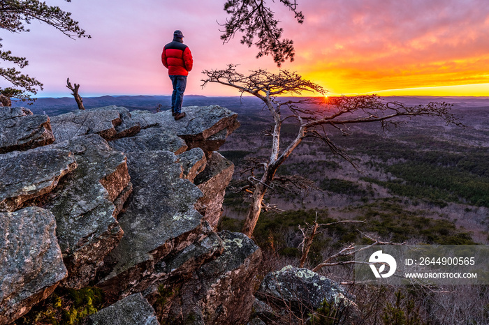 Man, person, standing on a rock high above a valley watching the sun setting in the distance, Pulpit Rock, Cheaha State Park, Alabama