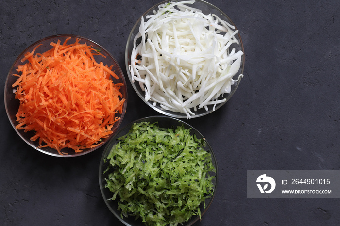 Vegetable salad of carrots, cucumber and cabbage in a Cup on a dark background