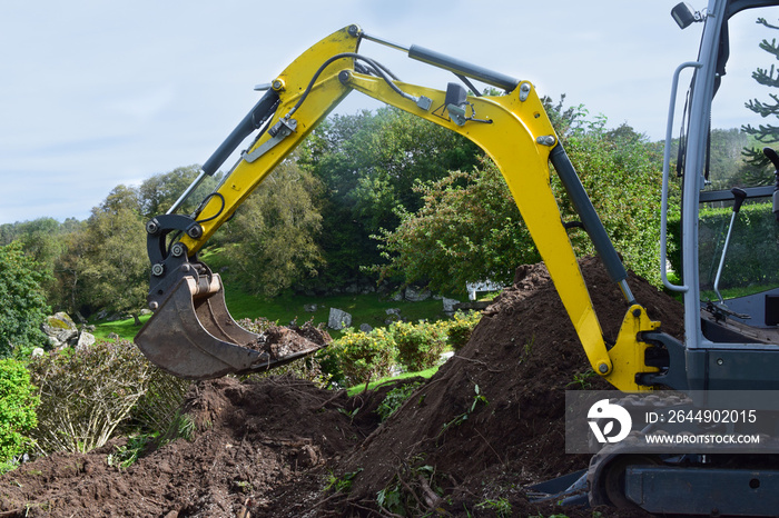 Mini Excavator dug trench in the garden. Works on laying communications.