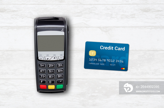 Payment terminal and credit card on wooden background