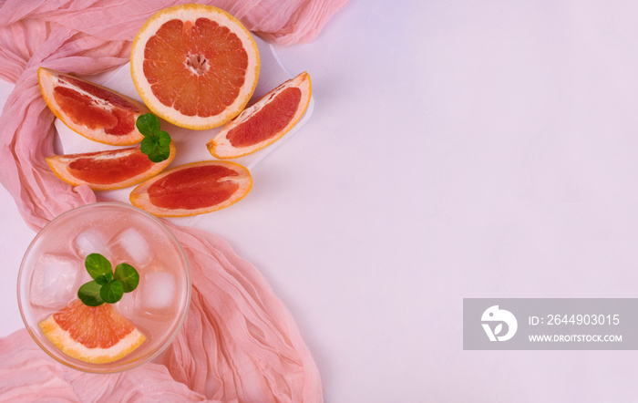 Grapefruit cocktail, drink with ice and mint on a white background. Copy space. Flat lay.