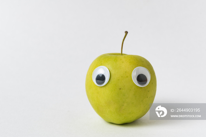 Cute Apple with funny face on white background. Green Apple with Googly eyes