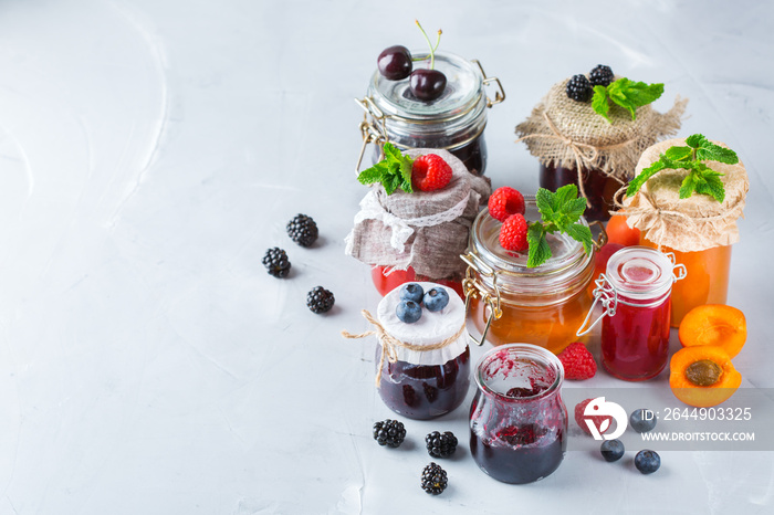 Assortment of seasonal berries and fruits jams in jars