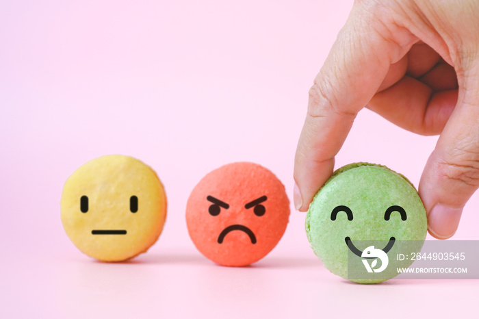 hand choose emotion face on green macarons ,good feedback rating and positive customer review, experience, satisfaction survey ,mental health assessment, child wellness, world mental health concept