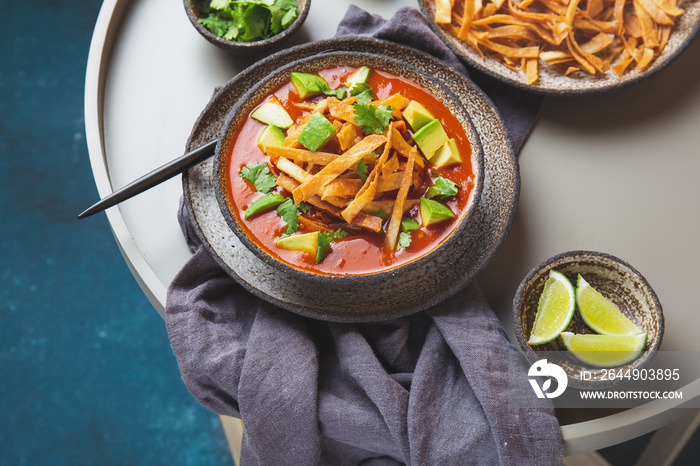 Mexican style table with spicy aztec soup with fried tortilla. Sopa azteca