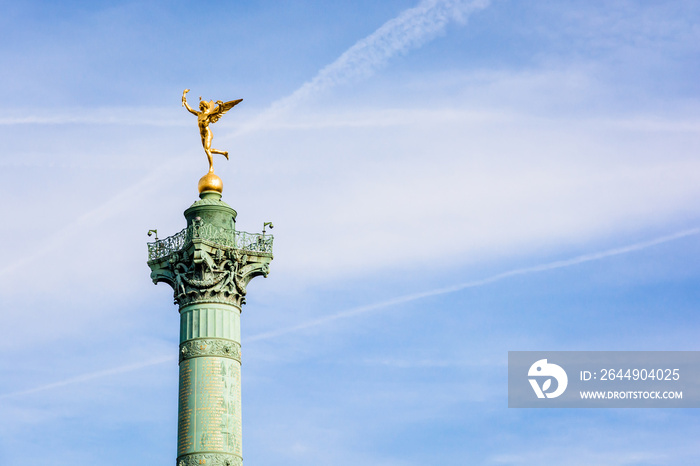The Genius of Liberty golden statue, by french sculptor Auguste Dumont, atop the July Column in the center of Place de la Bastille in Paris, France, against blue sky.